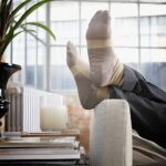 mans-feet-up-on-arm-of-couch-in-modern-home